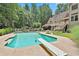 Beautiful backyard pool with diving board surrounded by lush landscaping and a privacy fence at 140 Silvermere, Fayetteville, GA 30215