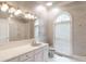 Well-lit bathroom features white vanity, tile floor, arched window, and a spacious shower area at 1806 Wynthrop Manor Sw Dr, Marietta, GA 30064