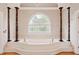 Bathroom with a soaking tub, large arched window and decorative pillars at 1806 Wynthrop Manor Sw Dr, Marietta, GA 30064