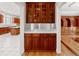 Butler's pantry showcases wooden cabinetry, marble countertop, and glass display cabinets at 1806 Wynthrop Manor Sw Dr, Marietta, GA 30064