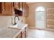 Functional laundry room with cabinets, granite countertop, sink and open shelves at 1806 Wynthrop Manor Sw Dr, Marietta, GA 30064