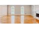Large living room features gleaming hardwood floors, two windows, and a fireplace at 1806 Wynthrop Manor Sw Dr, Marietta, GA 30064