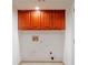 Storage area with red upper cabinets, utility hookups, and tile floors at 1806 Wynthrop Manor Sw Dr, Marietta, GA 30064