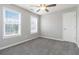 Carpeted bedroom with a ceiling fan, two windows, and white door at 1029 Chaterly Ct, Riverdale, GA 30296
