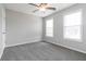 Carpeted bedroom with ceiling fan, two windows, and white door at 1029 Chaterly Ct, Riverdale, GA 30296