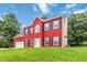 Charming two-story red brick home with a well-manicured lawn and a two-car garage at 1029 Chaterly Ct, Riverdale, GA 30296