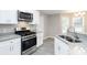 Well-lit kitchen features stainless steel appliances and granite countertops with gray plank flooring at 1029 Chaterly Ct, Riverdale, GA 30296