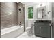 Bathroom features a tub-shower, grey vanity, and a window at 2461 Fernleaf Nw Ct, Atlanta, GA 30318