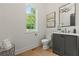 Stylish half-bathroom with marble countertops, dark vanity, and a sunlit window at 2461 Fernleaf Nw Ct, Atlanta, GA 30318