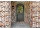 An arched front door featuring sidelight windows and elegant brick surround at 2461 Fernleaf Nw Ct, Atlanta, GA 30318