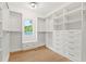 Spacious walk-in closet features custom shelves and drawers, with a window and bench seating at 2461 Fernleaf Nw Ct, Atlanta, GA 30318