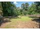 Large fenced backyard with mature trees and a manicured lawn, creating a peaceful outdoor space at 3381 Birchwood Trl, Snellville, GA 30078