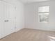 Bright bedroom featuring plush carpet, a double door closet, and a large window at 1119 Lockhart Way, Douglasville, GA 30135