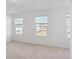 This bedroom has three windows, neutral carpet, and white walls at 1119 Lockhart Way, Douglasville, GA 30135