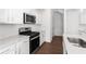 This kitchen has modern appliances, white cabinets, stainless steel, and wood flooring at 1119 Lockhart Way, Douglasville, GA 30135