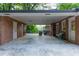 Spacious carport area with brick walls, covered parking, and a glimpse of the backyard at 1342 Old Johnson Ferry Ne Rd, Brookhaven, GA 30319