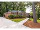 Charming brick home with a well-manicured lawn, mature trees, and a concrete driveway at 1342 Old Johnson Ferry Ne Rd, Brookhaven, GA 30319