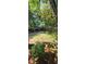 Wide shot of a single-story home with a long driveway nestled among trees in a wooded front yard at 1717 Briarbend Ct, Stone Mountain, GA 30088