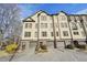 Townhome exterior featuring multiple stories, individual garages, manicured landscaping, and a brick driveway at 255 Southerland Ne Ter # 207, Atlanta, GA 30307