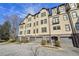 Townhome exterior featuring multiple stories, individual garages, manicured landscaping, and a brick driveway at 255 Southerland Ne Ter # 207, Atlanta, GA 30307
