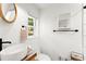 Bright bathroom features a stylish sink, a round mirror, and modern fixtures at 6875 Sunny Brook Lane Northeast, Sandy Springs, GA 30328