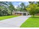 Well-maintained home boasting a long driveway, lush green lawn, and a convenient covered carport at 6875 Sunny Brook Lane Northeast, Sandy Springs, GA 30328