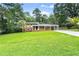 Inviting brick home with shuttered windows, covered carport, and a spacious, well-kept front lawn at 6875 Sunny Brook Lane Northeast, Sandy Springs, GA 30328