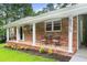 Charming brick home featuring a cozy front porch with seating, perfect for relaxing and enjoying the outdoors at 6875 Sunny Brook Lane Northeast, Sandy Springs, GA 30328
