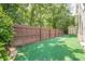 Well-maintained backyard with lush artificial turf and a wooden fence around the yard at 875 Soaring Cir, Marietta, GA 30062