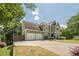 View of a two-story home with an attached two-car garage and a long driveway at 875 Soaring Cir, Marietta, GA 30062