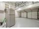 Large garage with two doors, gray floors, overhead storage, and a refrigerator at 875 Soaring Cir, Marietta, GA 30062