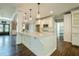 Open kitchen with white cabinets, granite countertops, hardwood floors, pendant lights and stainless steel appliances at 875 Soaring Cir, Marietta, GA 30062