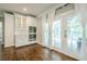 Eat-in kitchen features white cabinets, hardwood floors, stainless steel appliances, and double glass doors to the sunroom at 875 Soaring Cir, Marietta, GA 30062