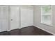 This bedroom offers dark wood floors, neutral walls, window with blinds and closet space at 1696 Thomas St, Decatur, GA 30032