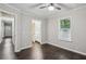Bedroom with ensuite bath boasts dark wood flooring, ceiling fan, neutral walls and window at 1696 Thomas St, Decatur, GA 30032