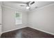 Bedroom with ceiling fan, window with blinds, dark wood floors, and neutral wall color at 1696 Thomas St, Decatur, GA 30032