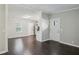 Open-concept living area with dark wood flooring, neutral walls, and a view into the kitchen area at 1696 Thomas St, Decatur, GA 30032