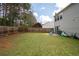 Expansive backyard with lush green grass, a wooden fence, and mature trees, creating a serene outdoor space at 245 Weatherstone Pointe Dr, Woodstock, GA 30188