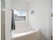 Bright bathroom featuring a soaking tub with chrome fixtures and a window offering natural light at 245 Weatherstone Pointe Dr, Woodstock, GA 30188