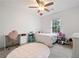 Bright bedroom features a ceiling fan, a window, and a desk, providing a comfortable and functional space at 245 Weatherstone Pointe Dr, Woodstock, GA 30188