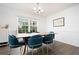 Stylish dining room featuring a wooden table with teal chairs, hardwood floors, and ample natural light at 245 Weatherstone Pointe Dr, Woodstock, GA 30188