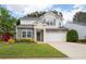 Charming two-story home boasts a manicured lawn, stone accents, and inviting curb appeal at 245 Weatherstone Pointe Dr, Woodstock, GA 30188