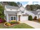 Beautiful two-story home with stone details, a gray roof, and a green lawn with flowerbeds at 245 Weatherstone Pointe Dr, Woodstock, GA 30188