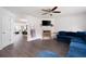 Bright living room featuring a fireplace, large sectional, and hardwood floors, perfect for relaxation at 245 Weatherstone Pointe Dr, Woodstock, GA 30188