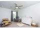 This bedroom features neutral walls, carpet, a fan, a crib and natural light at 3057 Windover Ln, Kennesaw, GA 30144
