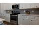 White kitchen with stainless appliances, light counters and a subway tile backsplash at 3057 Windover Ln, Kennesaw, GA 30144