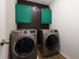 This laundry room includes modern washer and dryer, cabinets and dark accent wall at 3057 Windover Ln, Kennesaw, GA 30144