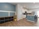 Transitional living area with blue accent wall open to kitchen with white cabinetry at 3057 Windover Ln, Kennesaw, GA 30144