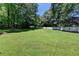 Expansive backyard featuring lush green grass, mature trees, and a wood privacy fence at 969 Bob Hannah Cir, Lawrenceville, GA 30044