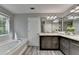 Bathroom featuring a soaking tub and a double sink vanity with gray cabinets at 969 Bob Hannah Cir, Lawrenceville, GA 30044